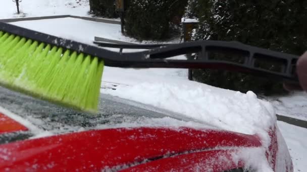 Πράσινη βούρτσα καθαρισμού χιόνι για το κόκκινο αυτοκίνητο. Δράση σε πραγματικό χρόνο. Χειμώνα. - Πλάνα, βίντεο