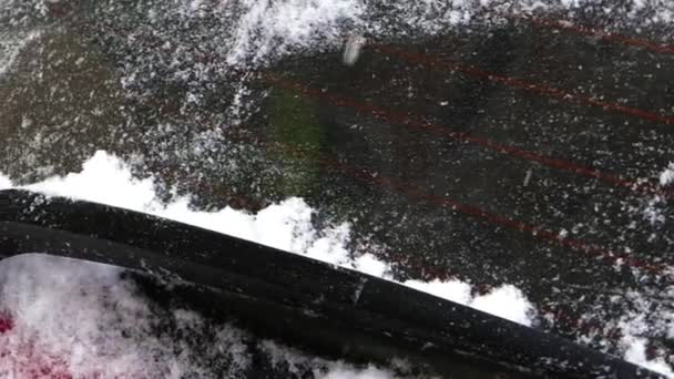Ο άνθρωπος που καθαρίζει χιόνι για το κόκκινο αυτοκίνητο. - Πλάνα, βίντεο