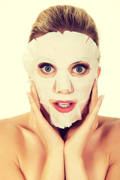Young surprised woman with facial mask - Foto, imagen