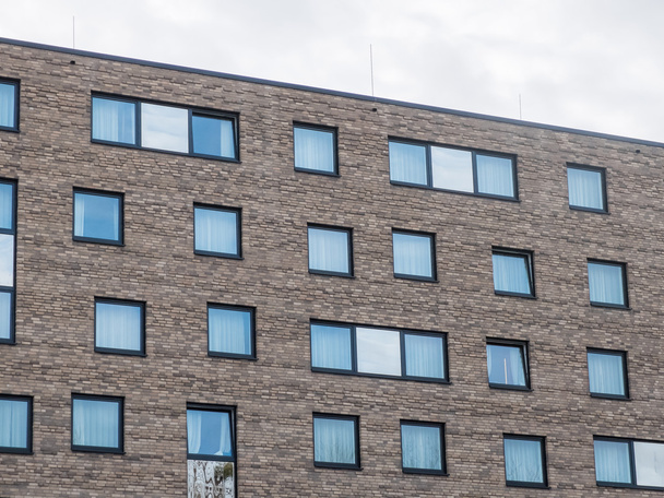 Edifício de apartamentos de tijolo de baixa ascensão com janelas
 - Foto, Imagem