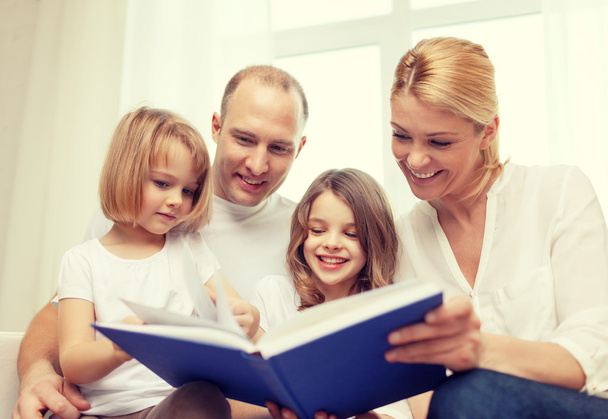 smiling family and two little girls with book - Fotoğraf, Görsel