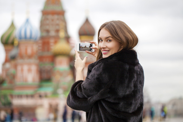 Young beautiful woman tourist taking pictures on mobile phone  - 写真・画像