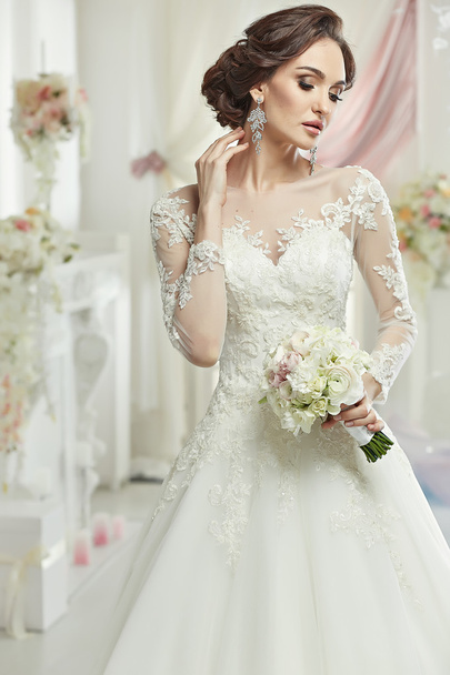 The beautiful woman posing in a wedding dress - Φωτογραφία, εικόνα
