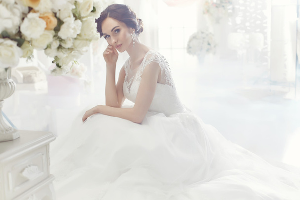 The beautiful woman posing in a wedding dress - Fotó, kép
