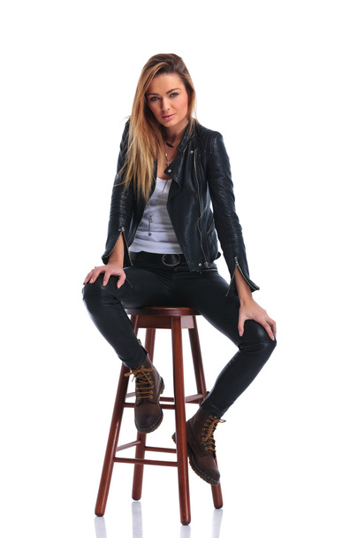 chica en botas y chaqueta de cuero pose sentado en blanco estudio bac
 - Foto, imagen