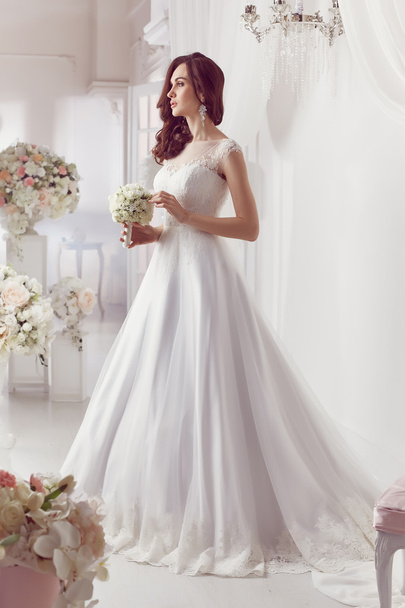 The beautiful woman posing in a wedding dress - Foto, Imagem