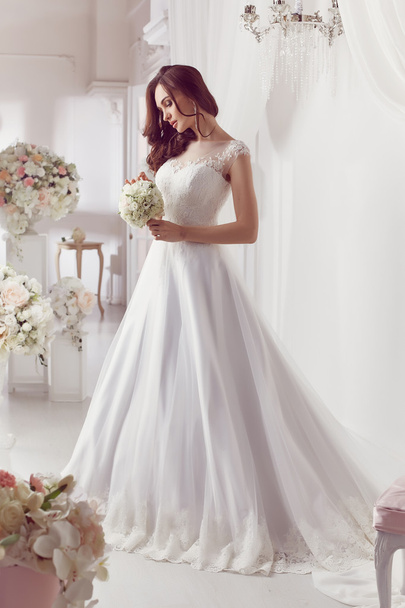 The beautiful woman posing in a wedding dress - Foto, imagen