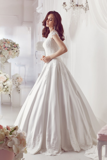 The beautiful woman posing in a wedding dress - Foto, Bild