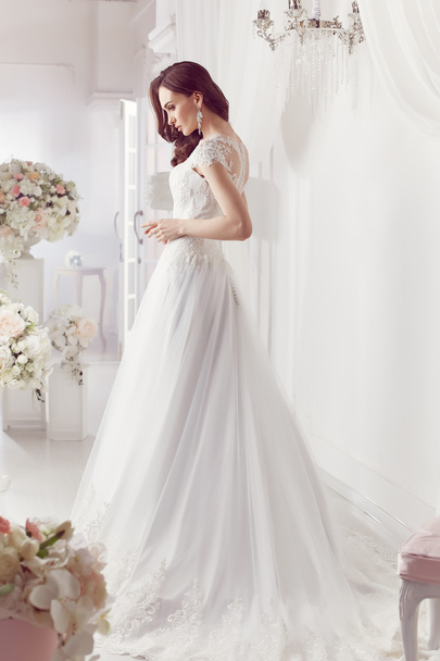 die schöne Frau posiert im Hochzeitskleid - Foto, Bild