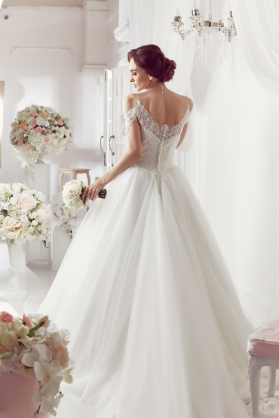 The beautiful woman posing in a wedding dress - Foto, Imagen
