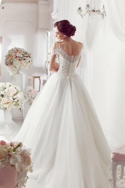 The beautiful woman posing in a wedding dress - Foto, afbeelding