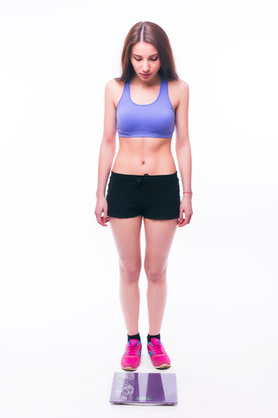 Sport girl Measuring Body Weight On Weighing Scale - Fotó, kép