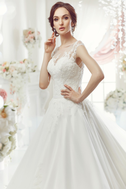 The beautiful woman posing in a wedding dress - Fotografie, Obrázek