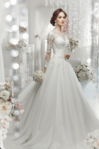 The beautiful woman posing in a wedding dress - Photo, image