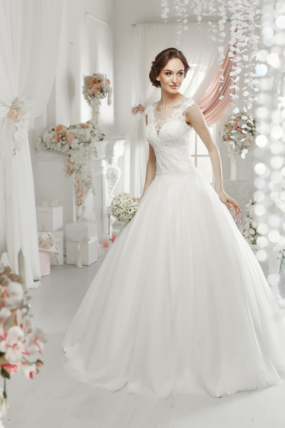 The beautiful woman posing in a wedding dress - Photo, Image