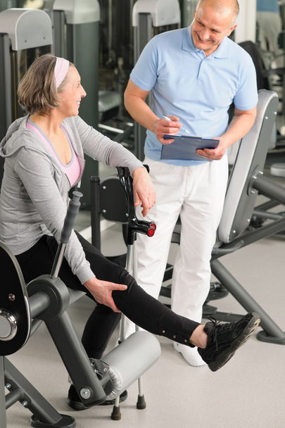 Physiotherapist assist active senior woman at gym - Foto, imagen