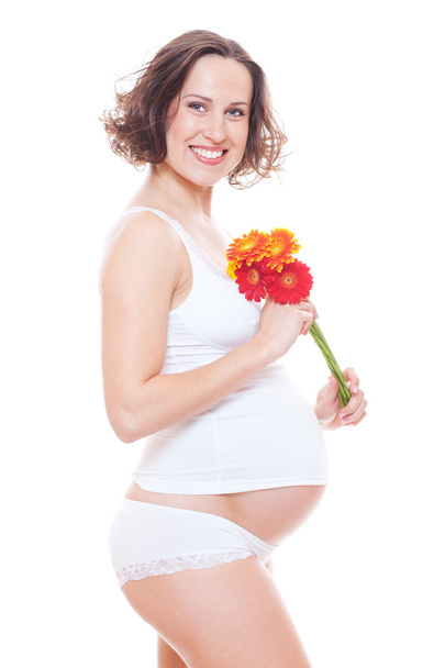 Студійне зображення усміхненої вагітної жінки з квіткою
 - Фото, зображення