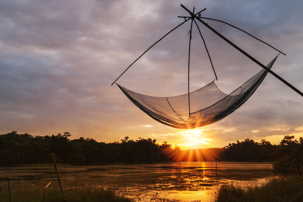 Asiáticos herramienta para la pesca con el color de la puesta del sol en el fondo borroso
 - Foto, imagen