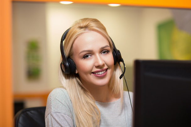 Attractive young woman in suit sitting at call center office and - Photo, Image