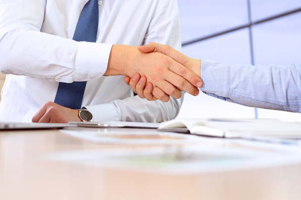 Close-up image of a firm handshake between two colleagues after signing a contract - Foto, immagini