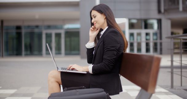 femme d'affaires travaillant sur ordinateur portable sur banc à l'extérieur
 - Photo, image
