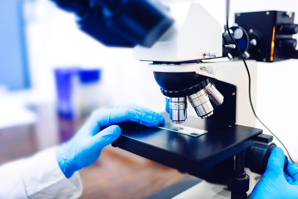 Details of medical laboratory, scientist hands using microscope for chemistry. Engineer Testing samples - Φωτογραφία, εικόνα