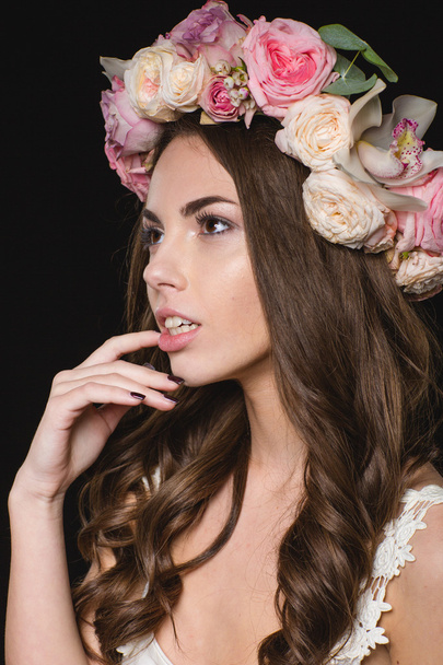 Tierna bonita hembra con hermoso pelo rizado en corona de rosas
  - Foto, imagen