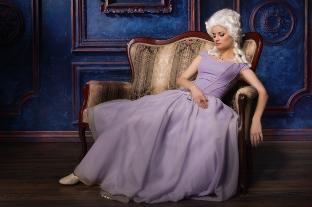 Femme en robe de style baroque historique et perruque blanche sur le canapé
 - Photo, image