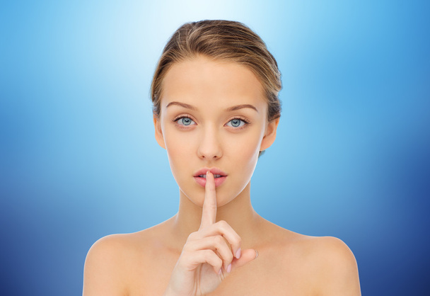 beautiful young woman holding finger on lips - Foto, immagini