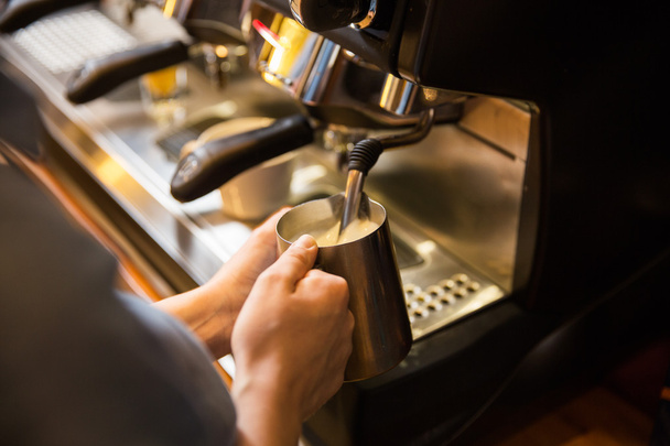 close up of woman making coffee by machine at cafe - 写真・画像