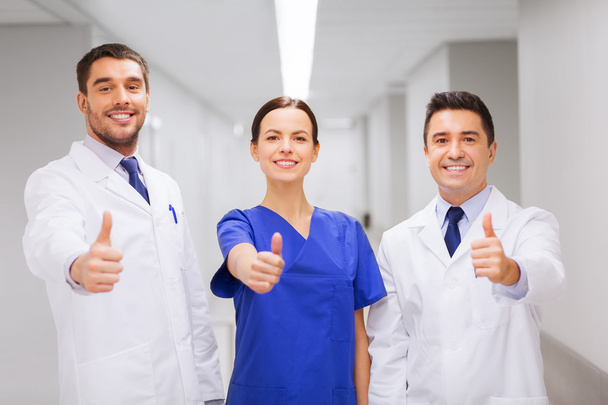 medics or doctors at hospital showing thumbs up - 写真・画像