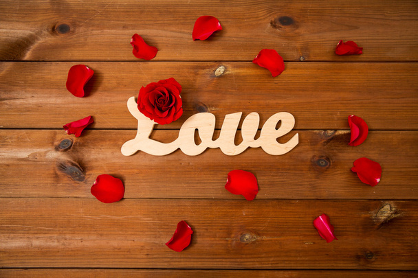 close up of word love cutout with red rose on wood - 写真・画像