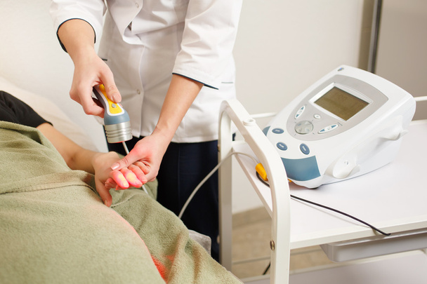 doctor performs the procedure of laser therapy on the patient's  - Valokuva, kuva