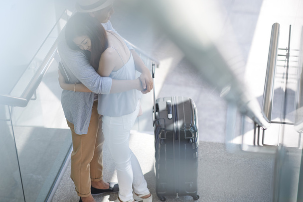 Asian girl hugging her boyfriend in airport - Photo, Image