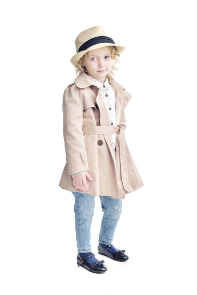 Fashionable child. Blonde girl in a stylish raincoat and hat. - Фото, изображение