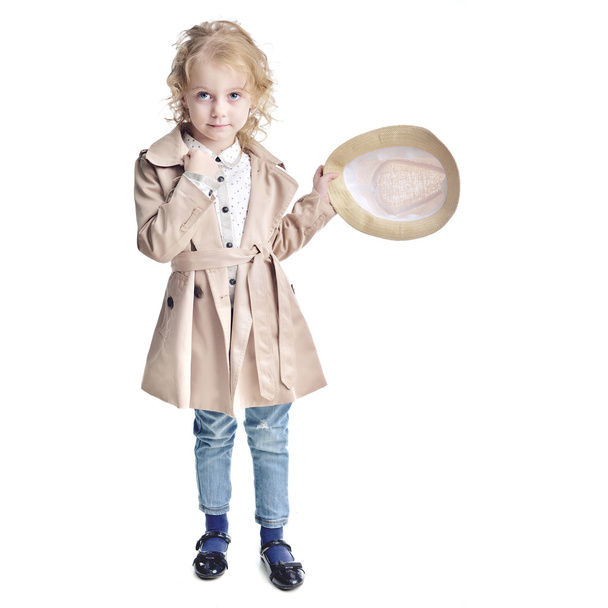 Fashionable child. Blonde girl in a stylish raincoat and hat. - Fotó, kép