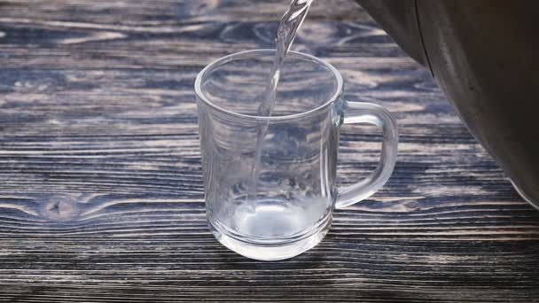 Vaso de té con bolsita de té y verter agua en cámara lenta
 - Metraje, vídeo