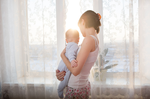 Loving mother playing with her baby on window - Valokuva, kuva