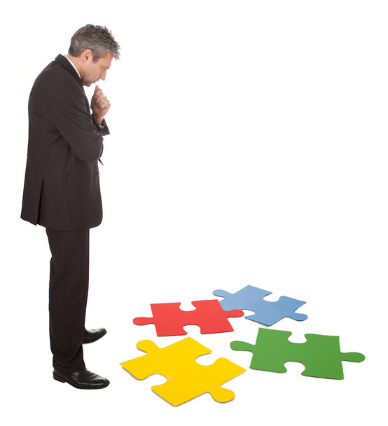 Senior businessman assembling a jigsaw puzzle - Φωτογραφία, εικόνα