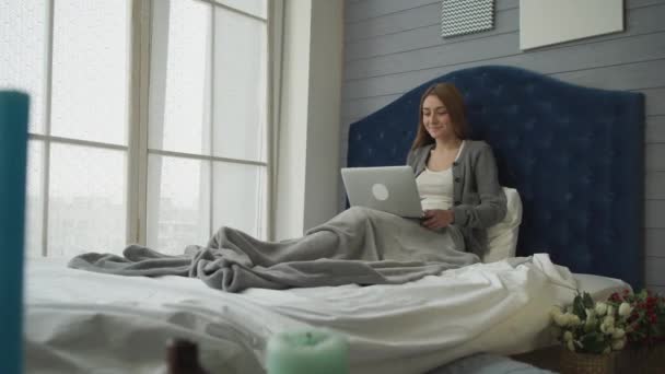Sabah gezisi, kız yatakta bir laptop için konuşuyor - Video, Çekim