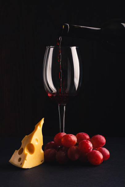 Bir şişe kırmızı şarap, cam ve üzüm demet - Fotoğraf, Görsel