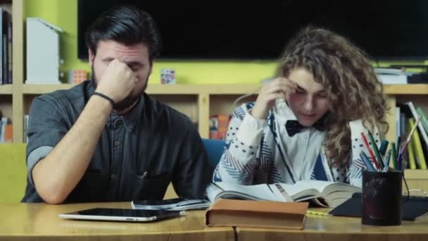 pareja de estudiantes cansados sentados en la sala de clases cámara lenta
 - Metraje, vídeo