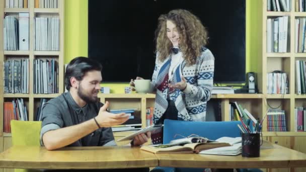 lachende studenten met behulp van een tablet in de klasse kamer slow motion - Video