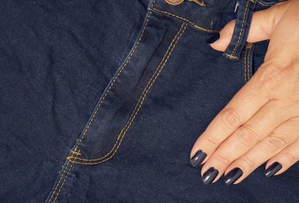 Jeans en een vrouwelijke vingers - Foto, afbeelding