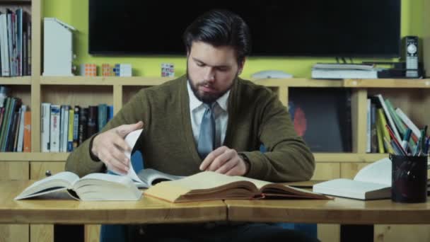мужчина студент ищет необходимую информацию в книгах замедленной съемки
 - Кадры, видео
