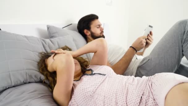 mulher sonolenta e homem usando tablet na cama câmera lenta
 - Filmagem, Vídeo