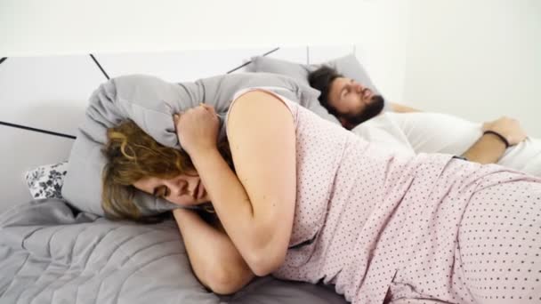 Kobieta, chowając głowę w poduszkę podczas snu z człowieka zwolnionym tempie - Materiał filmowy, wideo