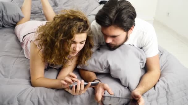 男と女がベッドのスローモーションでのガジェットの使用 - 映像、動画