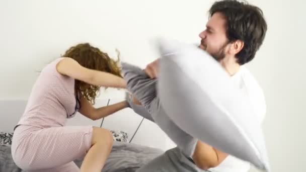 funny couple pillow fighting in bed slow motion - Felvétel, videó