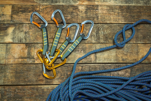 Підйомна мотузка і карабін на дерев'яних дошках
 - Фото, зображення